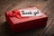 Red gift box and label with the words thank you on a wooden background: concept of expressing gratitude and thanks