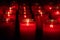 Red glass candles lit in a dark church