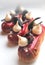 Red glazed raspberry eclairs with mirror glaze, meringues and chocolate decorations