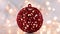Red glitter Christmas ornament on light theme with blinking lights.