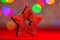 Red glittery decoration in a colorful Christmas composition isolated on background of blurred lights