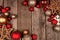 Red and gold Christmas ornament double corner border, top view on a wood background