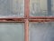 Red Gothic style cross. Christian cross in the window. Abstract cross in church interior