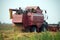 Red grain harvester combine in a field