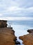 Red Granite Cracked Coastline at Sunset, Unrecognizable Men Fishing