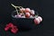 Red grapes in black bowl with flower