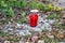 Red graveyard candle on white stony ground.