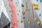 Red-gray wall of climbing wall, with ledges and ropes with carbines