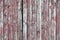 Red-gray wooden background. vertical boards. old paint peels off. old boards. Red gray wood texture of a worn painted board. Red