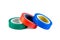 Red, green and blue adhesive insulating electrical tape reels stack isolated on white background.