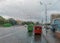 Red and green buses on a city street through a cloudy windshield in rain drops during a downpour