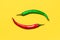 Red and Green Chili Peppers Form Yin Yang a Symbol on Yellow Background. Flat Lay
