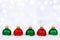 Red and green Christmas ornaments in snow with twinkling background