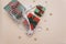 Red, green gift boxes lie in an eco-friendly white string bag on a beige background with gold stars. top view.