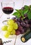 Red and green grapes, bottle, corkscrew and glass of red wine