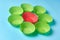Red and green paper molds for baking muffins in form of flower lies on blue desk on kitchen