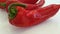 red and green pepper on a white background pouring water