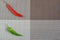 Red and green peppers on a rectangular background of gray, brown and capsicum on a rectangular background of gray, brown and white