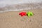 Red and green starfish-shaped molds on the sand