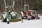 Red and green tractors dusted with snow