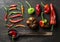 Red and green vegetables with rustic old spoon on dark wooden background, top view