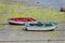 Red and green wooden fishing boats dries ashore