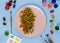 Red, green and yellow fried vegetables on a pink plate. on the sides of the plate are an art brush and palettes of colorful paints