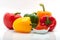 Red, green, yellow and orange peppers and paprika in a dish isolated on white background