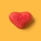 Red gummy heart on a yellow background