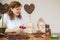 Red hair mom and blonde daughter make crafts from coffee beans in the form of trees in pots at home sitting at the table