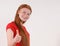 Red hair tennager girl in a red shirt showing a thumbs-up