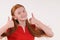 Red hair tennager girl in a red shirt showing a thumbs-up on both hands