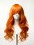 Red hair wig on a woman mannequin on white background.