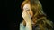 Red-haired actress in the dressing room makes eye makeup with blue shadows preparing to go on stage.