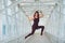 The red-haired aerial gymnast in a sports combo performs at the air hoop in a pedestrian crossing