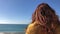 Red-haired beautiful woman looks far into the sea horizon