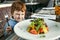 Red haired boy with forks eating salad