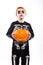 Red haired boy in skeleton costume holding a pumpkin. Halloween.