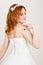 Red-haired bride in a wedding dress, bright unusual appearance. Beautiful wedding hairstyle and bright make-up