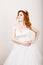 Red-haired bride in a wedding dress, bright unusual appearance. Beautiful wedding hairstyle and bright make-up