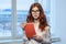 red-haired business woman wearing glasses red notepad Professional