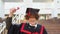 Red -haired curly guy with braces stands in a master's mantle and triumphantly raises his diploma over his head