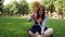 Red-haired girl blows soap bubbles in the park