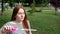 Red-haired girl blows soap bubbles in the park Slow Motion