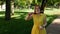 Red-haired girl blows soap bubbles in the park.yellow dress