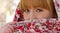 The red-haired girl closes half of his face with a scarf.