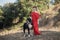 Red-haired girl in red dress walks with a big great dane