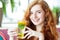 Red-haired girl smiles. Tea with mint and citrus. Concept of lifestyle, drinks and healthy eating