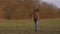 A red-haired girl walking in the field with a smartphone with headphones