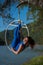 Red-haired gymnast in a blue suit doing the difficult exercises at the air ring in nature